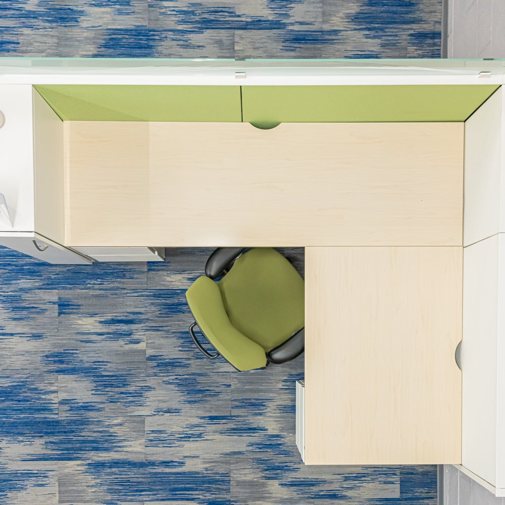 Workstation with green walls, light-colored laminate, and spacious worktop.