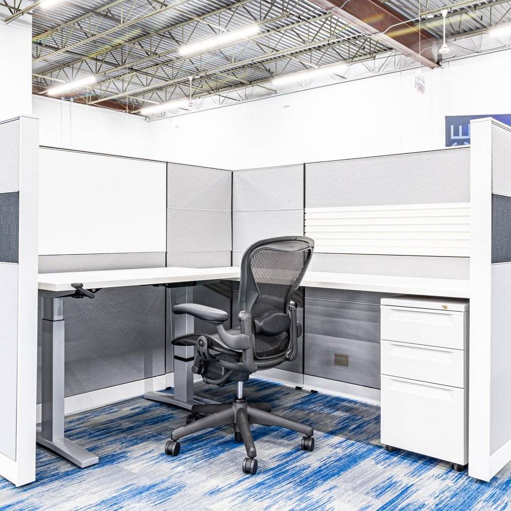 Ergonomic task chair in a modern cubicle workspace.