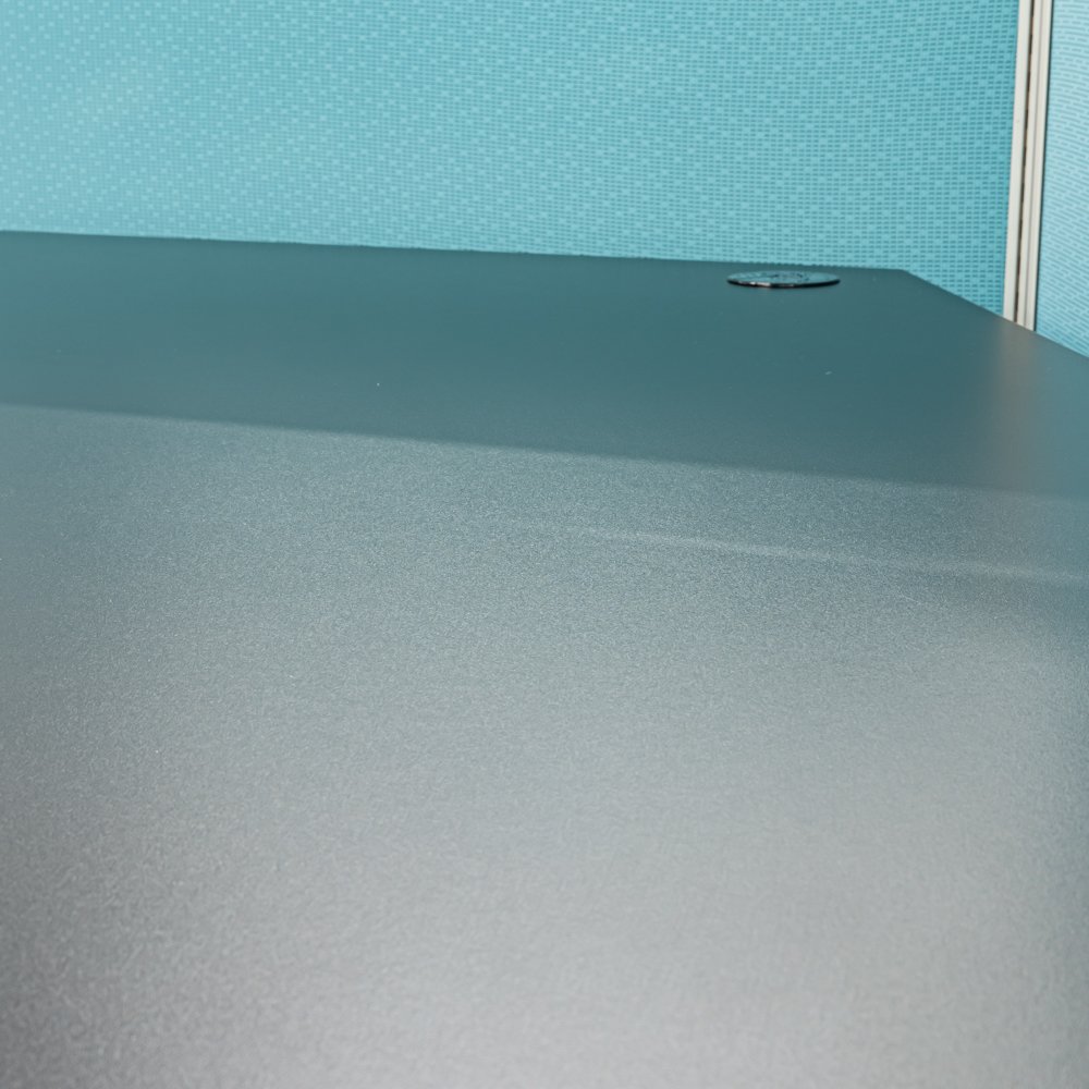 Close-up of the CNC-crafted black laminate worksurface in the Haworth 3-Pack Cubicle.