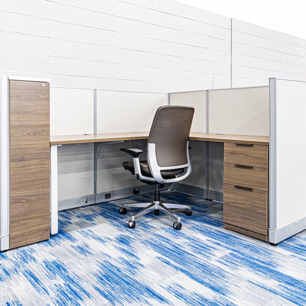 Earth-tone cubicle with ergonomic chair and ample storage for a tidy workspace.